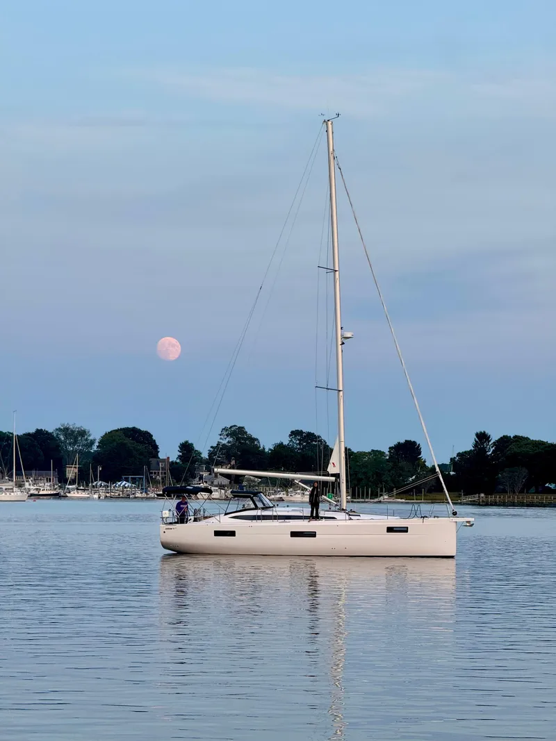Slide: The Image of 2024 Elan Impression 43 sailboat on calm water with a pink moon in the background. - 4
