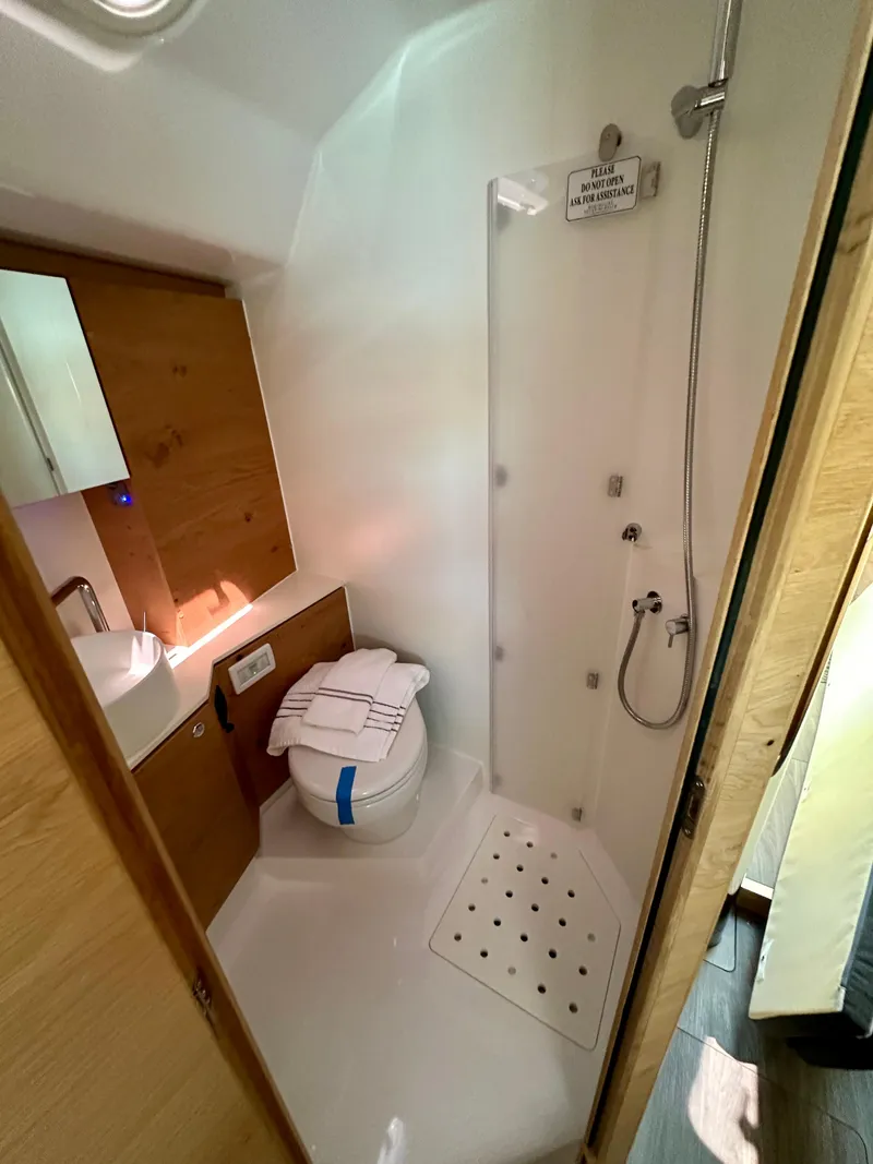Slide: The Image of 2024 Elan Impression 43 yacht bathroom with shower, sink, and toilet. - 40