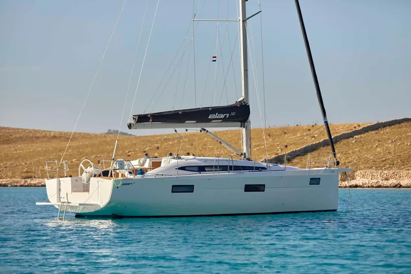 Slide: The Image of 2024 Elan Impression 43 sailboat anchored in clear blue water. - 7
