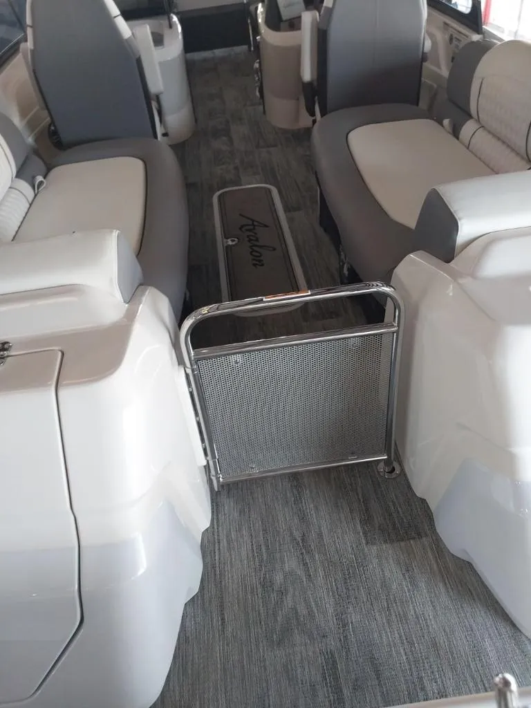 Slide: The Image of 2023 Avalon Excalibur Quad Lounge Windshield boat with Mercury outboard motor on display. - 9