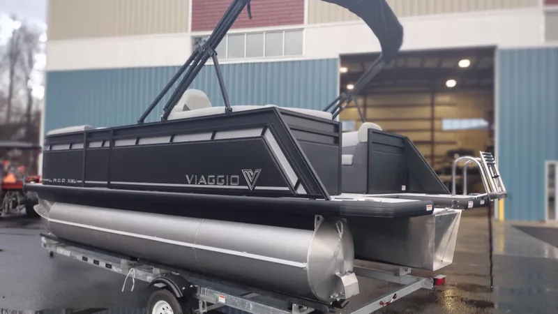 Slide: The Image of 2024 Viaggio Lago X18U pontoon boat on trailer outside a warehouse. - 5