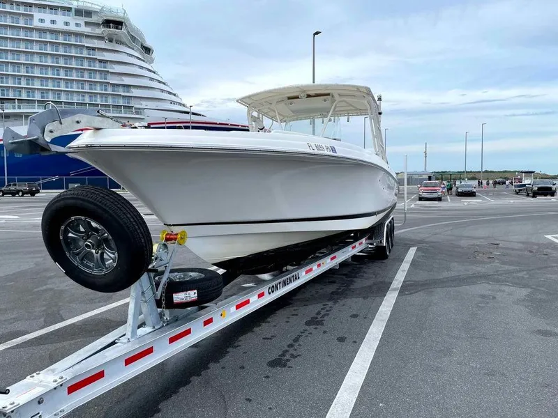 Slide: The Image of 2014 Wellcraft 35 Scarab Tournament boat on a trailer in a parking lot. - 1