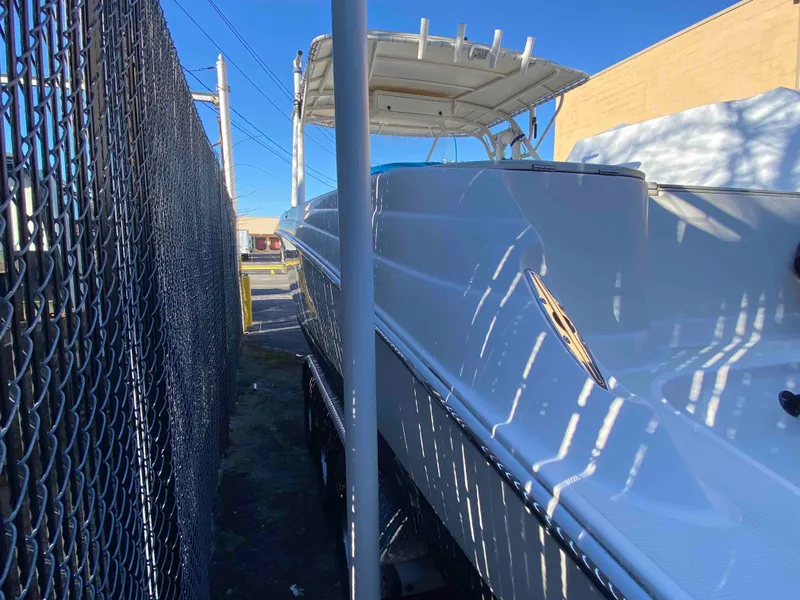 Slide: The Image of 2014 Wellcraft 35 Scarab Tournament boat parked beside a chain-link fence. - 10