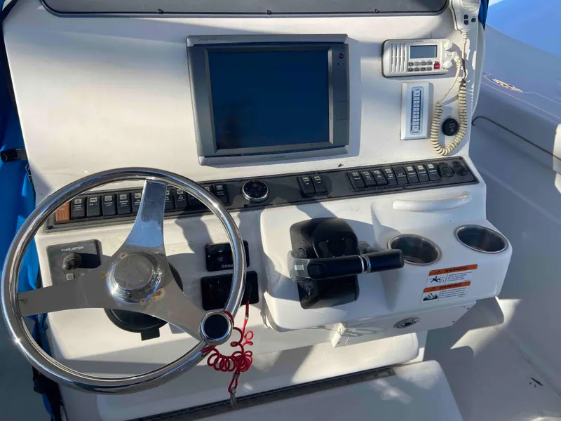 Slide: The Image of Control panel of a 2014 Wellcraft 35 Scarab Tournament boat with steering wheel and navigation screen. - 7