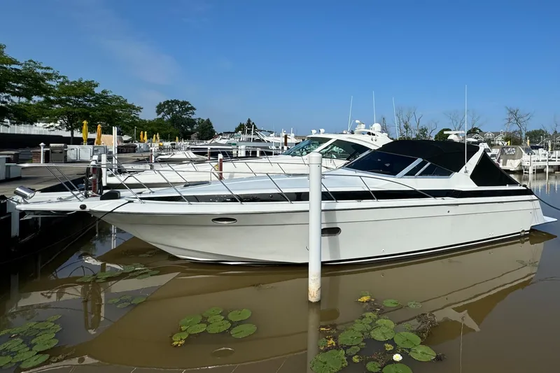 Slide: The Image of 1988 Chris-Craft Amerosport yacht docked in a marina with lily pads. - 15