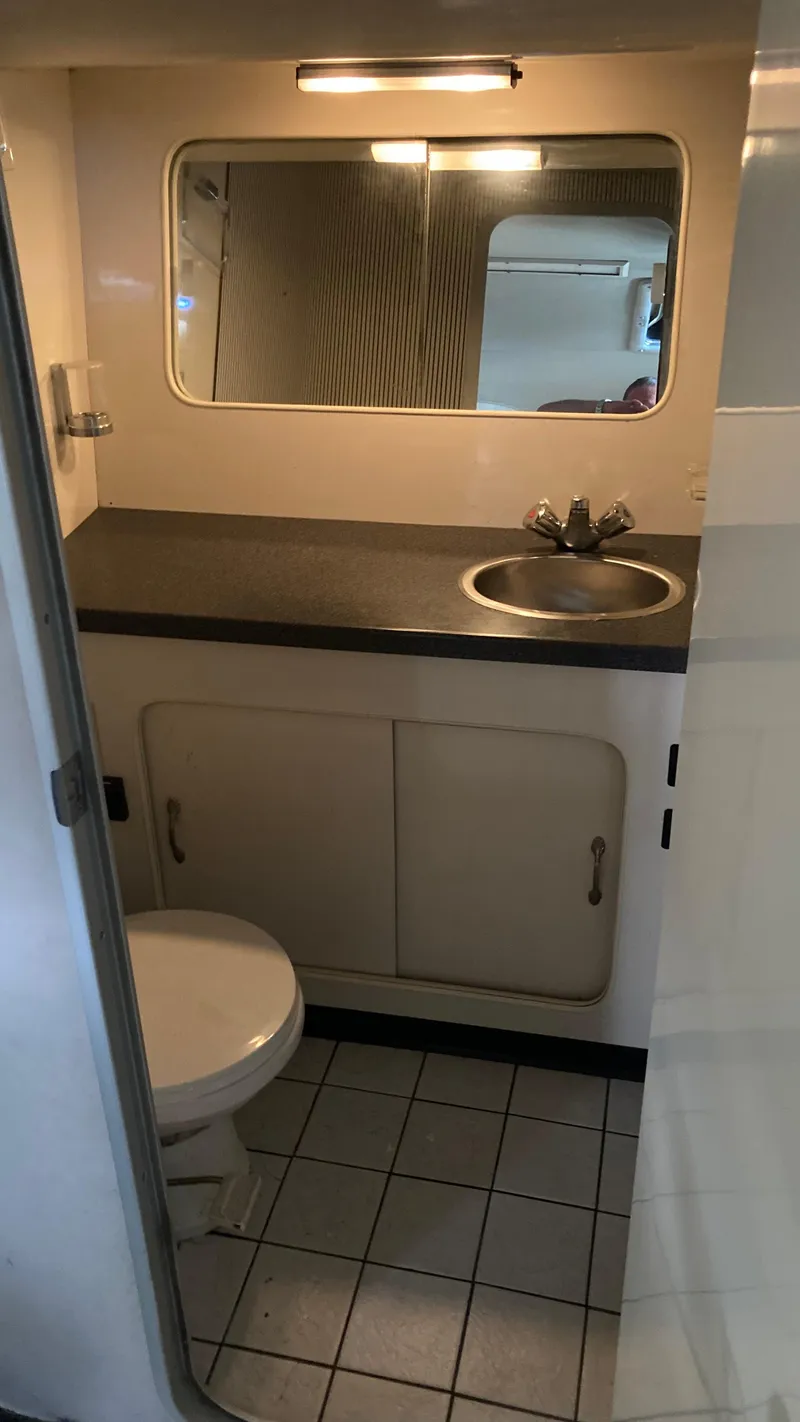 Slide: The Image of 1988 Chris-Craft Amerosport boat bathroom with sink, mirror, and toilet. - 30