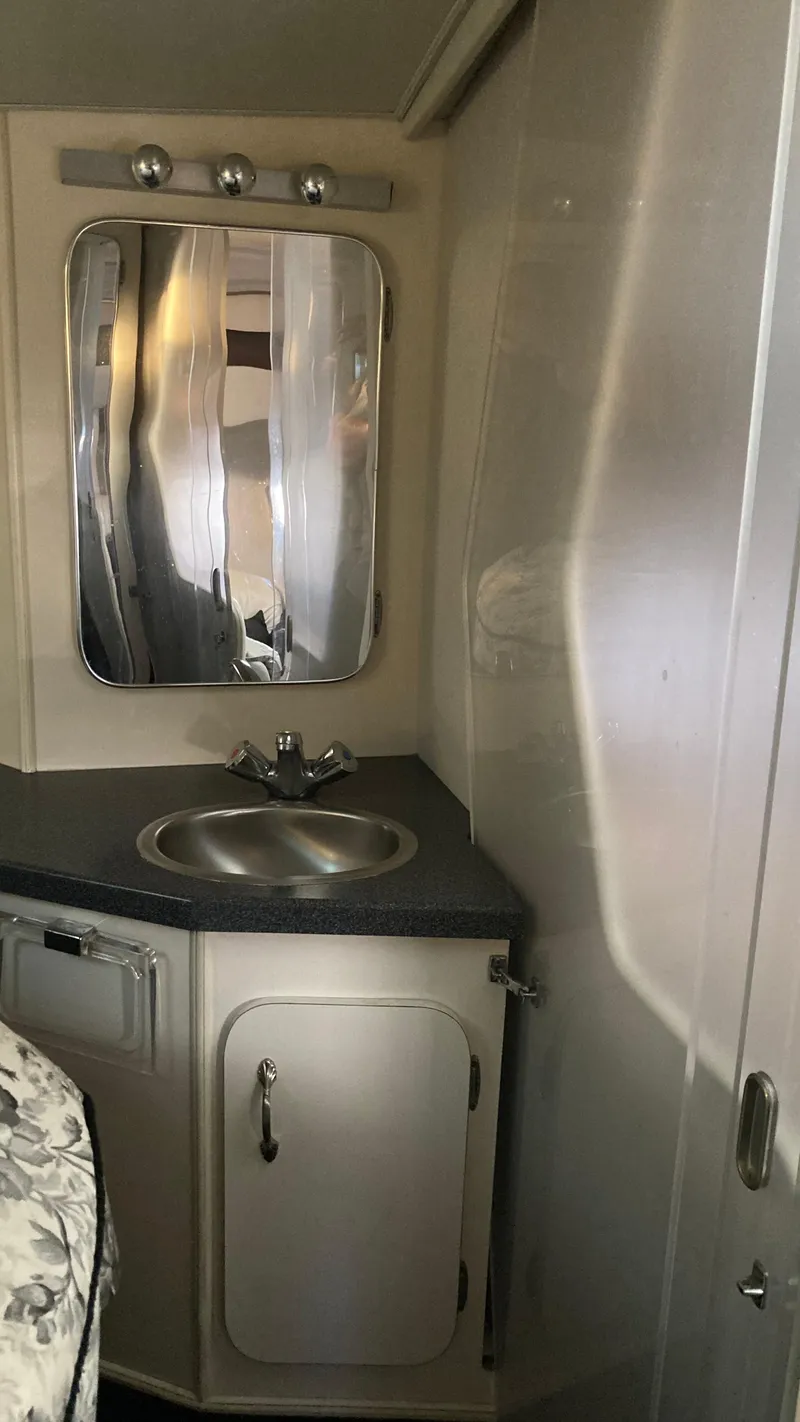 Slide: The Image of 1988 Chris-Craft Amerosport bathroom with sink, mirror, and storage cabinet. - 36