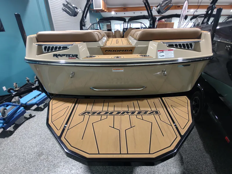 Slide: The Image of 2024 Moomba Makai boat rear view with Raptor Indmar engine, tan seating, and Moomba logo. - 14