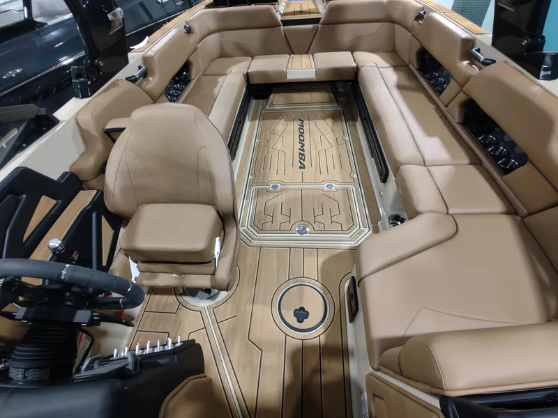 Slide: The Image of 2024 Moomba Makai boat interior with tan leather seats and wood flooring. - 6