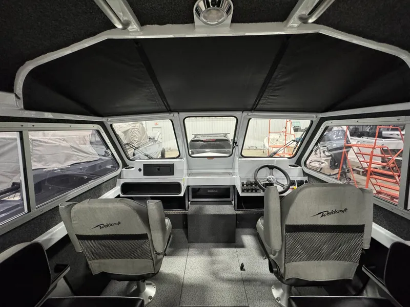Slide: The Image of 2024 Weldcraft 200 Revolution F200 boat interior with dual seats and steering console. - 11