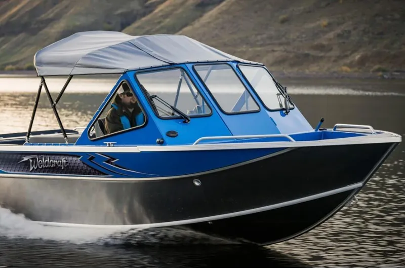 Slide: The Image of 2024 Weldcraft 200 Revolution F200 boat cruising on a lake. - 19