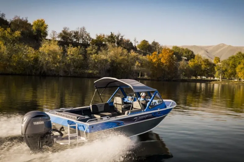 Slide: The Image of 2024 Weldcraft 200 Revolution F200 boat cruising on a scenic lake. - 24