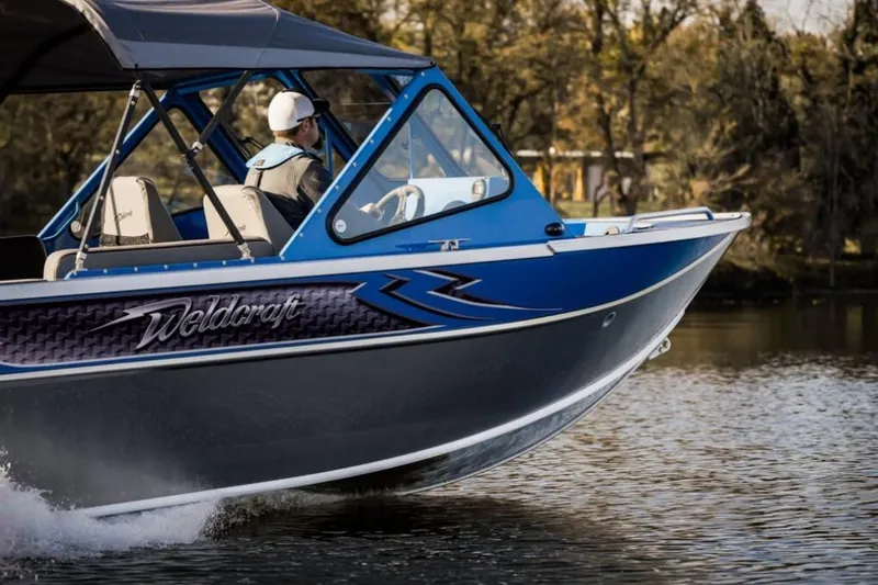 Slide: The Image of 2024 Weldcraft 200 Revolution F200 boat cruising on a lake. - 21