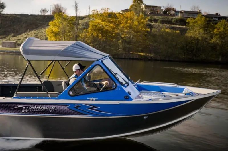 Slide: The Image of 2024 Weldcraft 200 Revolution F200 boat cruising on a lake. - 22