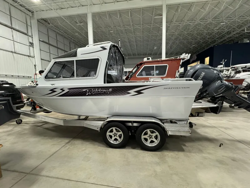 Slide: The Image of 2024 Weldcraft 200 Revolution F200 boat in stock, displayed in a showroom. - 7