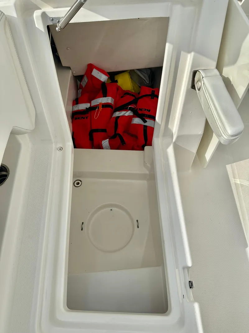 Slide: The Image of Storage compartment on a 2021 World Cat 280 DC-X boat with life jackets inside. - 16
