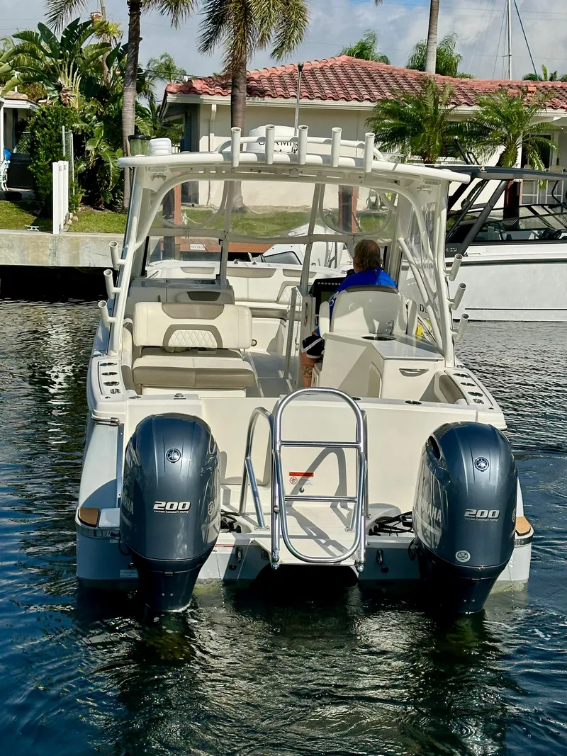 Slide: The Image of 2021 World Cat 280 DC-X boat with dual engines, docked in a sunny marina. - 6