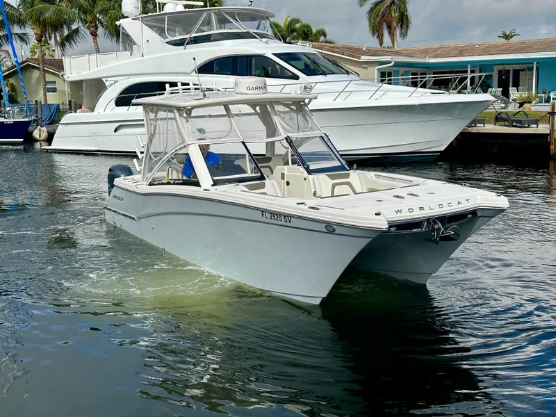 Slide: The Image of 2021 World Cat 280 DC-X boat cruising in a marina, with yachts and palm trees in the background. - 7