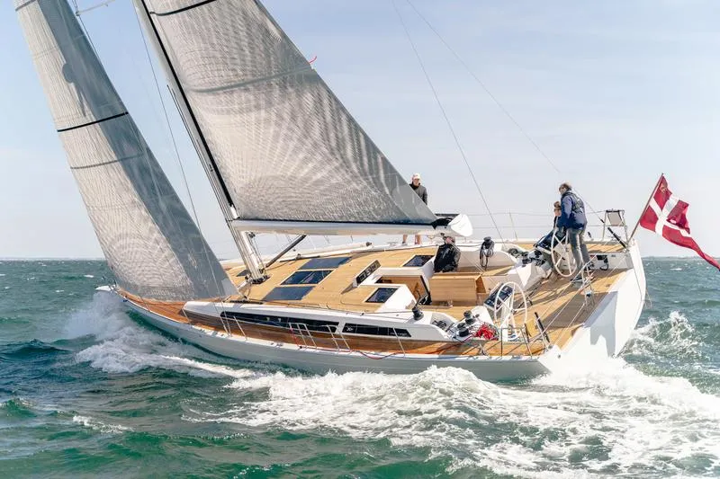 Slide: The Image of 2025 X-Yachts X-4.9 sailing on open water with crew onboard. - 2