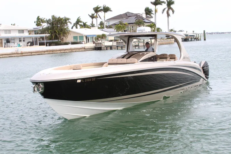 Slide: The Image of 2021 Mystic Powerboats M4200 cruising in a coastal area. - 12