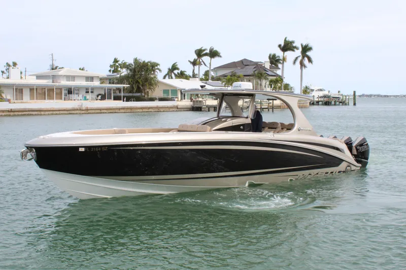 Slide: The Image of 2021 Mystic Powerboats M4200 cruising in a coastal area. - 16