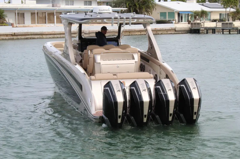 Slide: The Image of 2021 Mystic Powerboats M4200 with quad outboard engines cruising in a marina. - 19