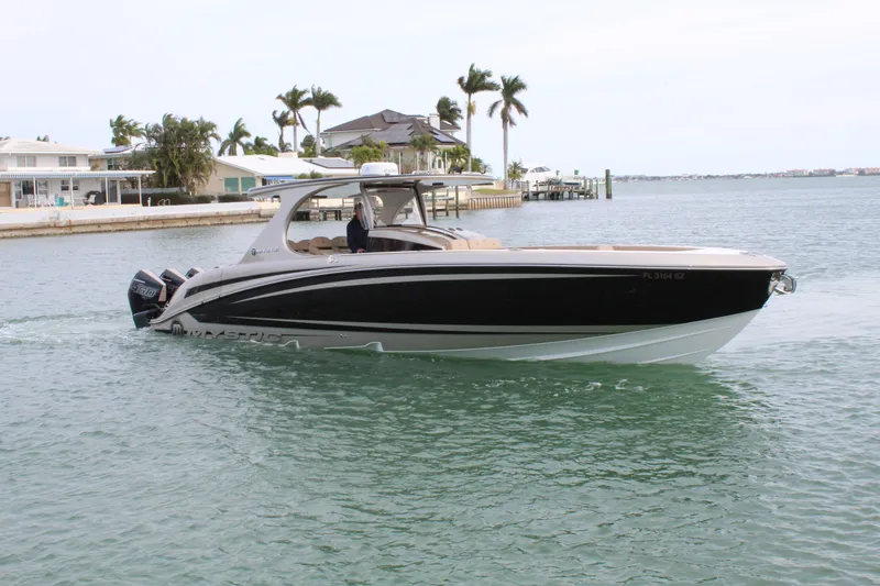 Slide: The Image of 2021 Mystic Powerboats M4200 cruising in a coastal waterway. - 21