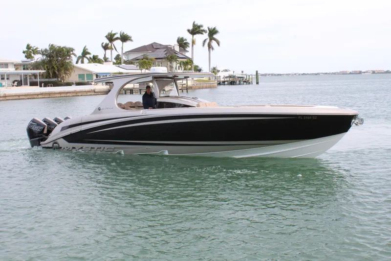 Slide: The Image of 2021 Mystic Powerboats M4200 cruising in a coastal area. - 22