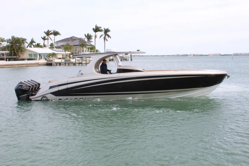 Slide: The Image of 2021 Mystic Powerboats M4200 cruising on a calm, tropical waterway. - 23