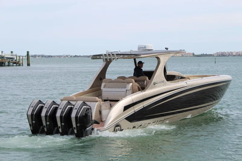 Slide: The Image of 2021 Mystic Powerboats M4200 cruising on the water with four powerful outboard engines. - 26