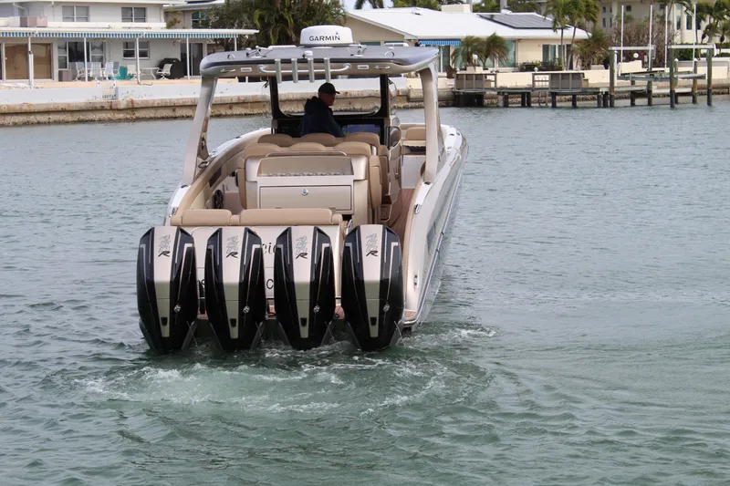 Slide: The Image of 2021 Mystic Powerboats M4200 cruising in a coastal area with four powerful outboard engines. - 27