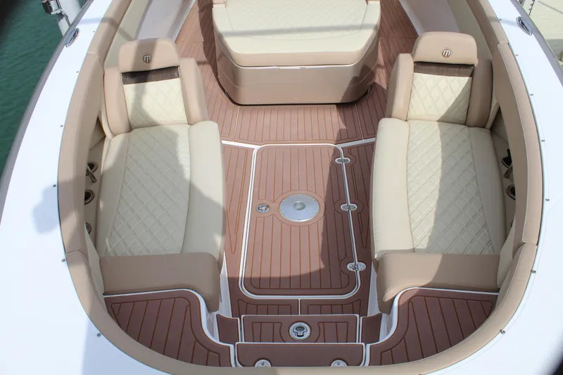 Slide: The Image of 2021 Mystic Powerboats M4200 interior seating area with tan and cream upholstery. - 32