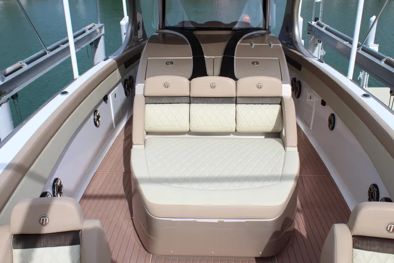 Slide: The Image of 2021 Mystic Powerboats M4200 interior seating area with luxurious beige and brown upholstery. - 33