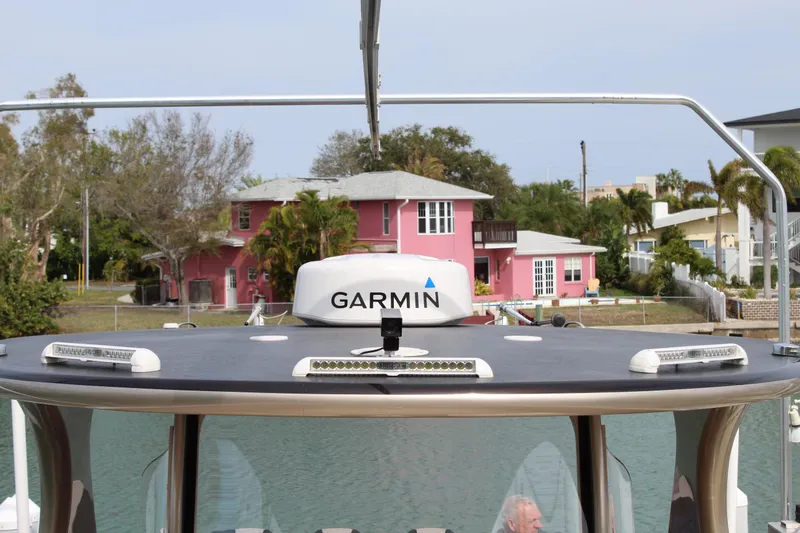 Slide: The Image of 2021 Mystic Powerboats M4200 with Garmin navigation system docked near waterfront homes. - 44