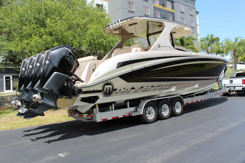 Slide: The Image of 2021 Mystic Powerboats M4200 on a trailer, featuring triple outboard engines. - 9