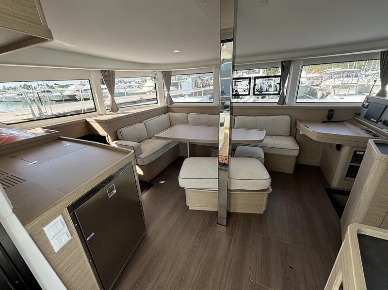 Slide: The Image of Interior of 2025 Lagoon 42 catamaran with modern seating and panoramic windows. - 16
