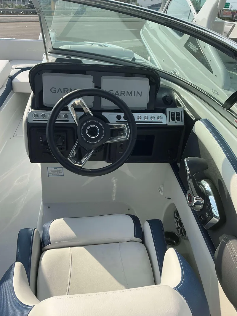 Slide: The Image of 2024 Crownline 290 XS boat cockpit with Garmin displays and steering wheel. - 11