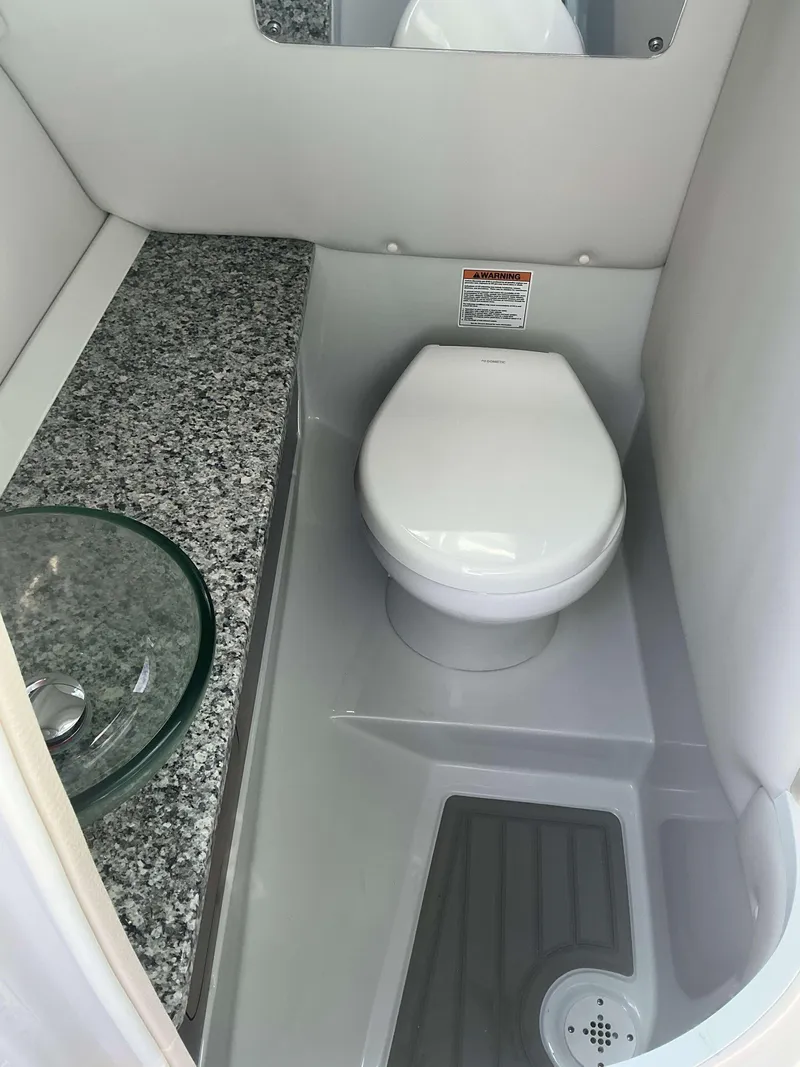 Slide: The Image of 2024 Crownline 290 XS boat bathroom with modern toilet and granite countertop. - 13