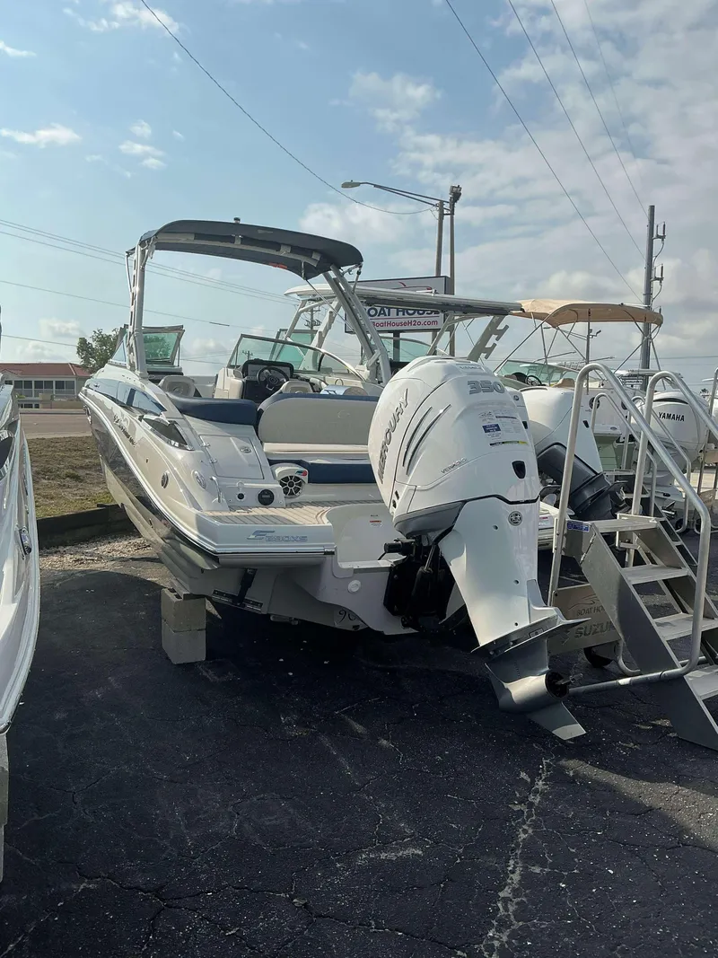 Slide: The Image of 2024 Crownline 290 XS boat with outboard motor on display in a marina. - 4