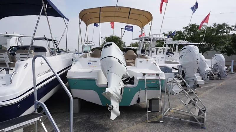 Slide: The Image of 2024 Hurricane 218 SS boat with outboard motor at a dealership. - 12