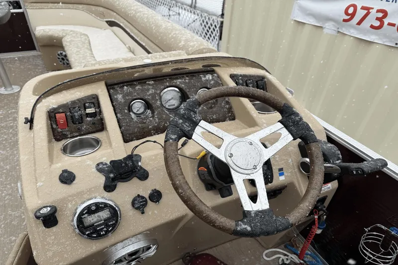 Slide: The Image of 2017 Bennington SX24 boat helm with steering wheel and controls, covered in snow. - 16