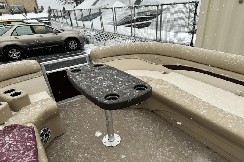 Slide: The Image of Bennington SX24 2017 pontoon boat interior with snow-covered seats and table. - 20