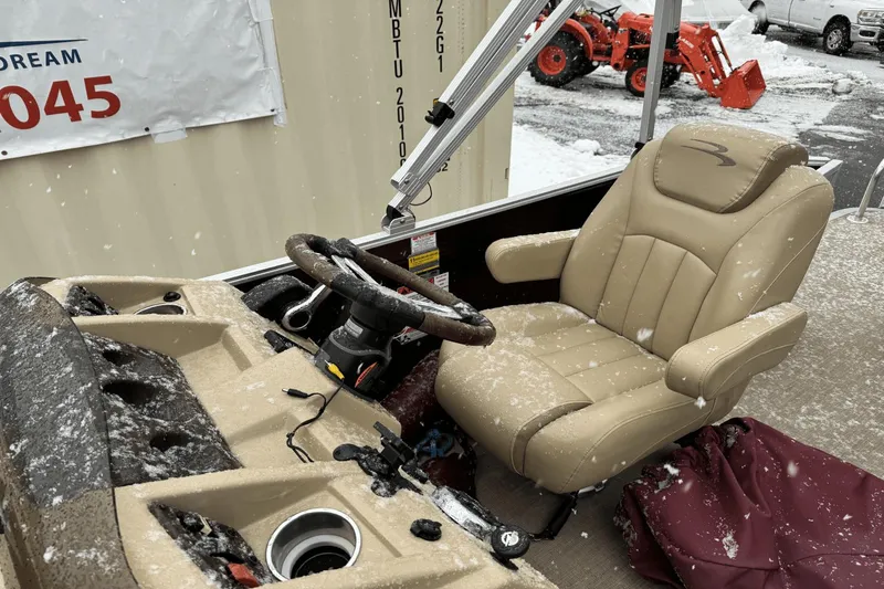 Slide: The Image of 2017 Bennington SX24 boat cockpit with snow-covered steering wheel and captain's chair. - 22