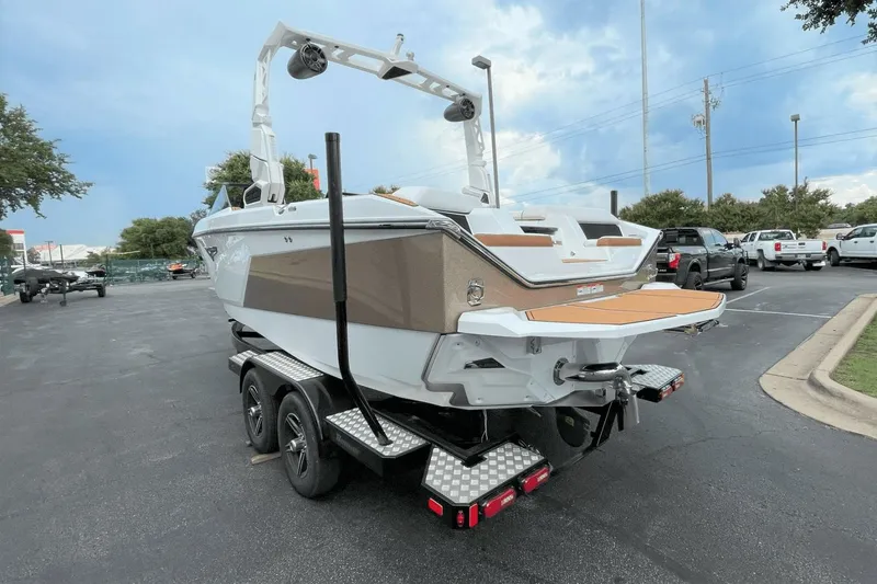 Slide: The Image of 2023 Nautique S21 Super Air boat on a trailer in a parking lot. - 13