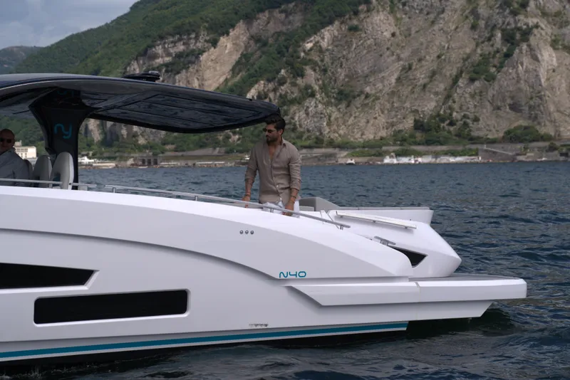 Slide: The Image of Modern Nassima Yacht N40 (2025) cruising on a scenic lake with mountainous backdrop. - 3