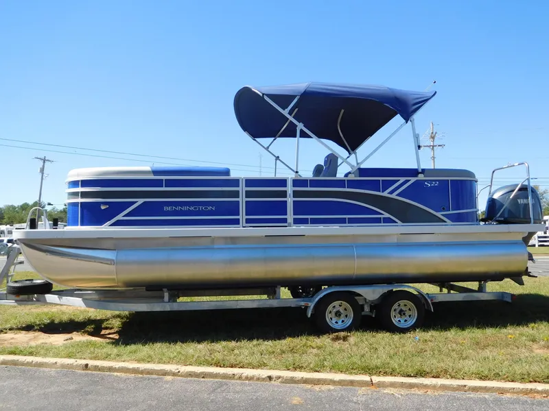 Slide: The Image of 2024 Bennington 22 SSR pontoon boat with blue canopy on a trailer. - 1