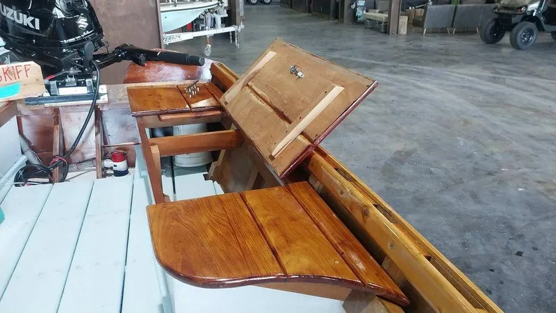 Slide: The Image of Custom 2020 16 Skiff with wooden seats and storage compartments in a workshop. - 6