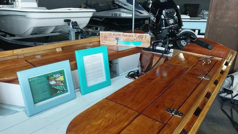 Slide: The Image of Custom 2020 16 Skiff boat with wooden deck and framed information displays. - 9