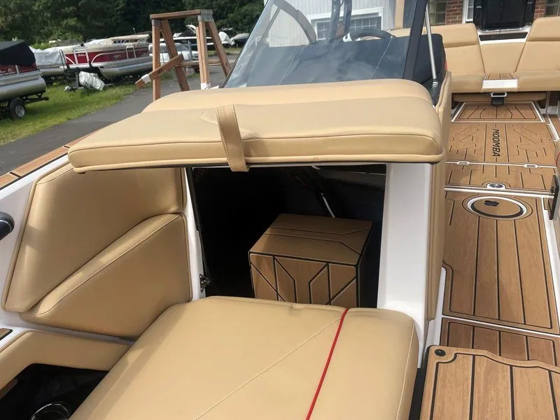 Slide: The Image of 2024 Moomba Tykon boat interior with tan seating and wood-style flooring. - 10