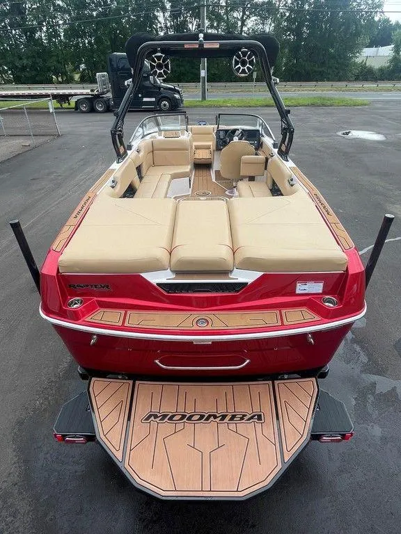 Slide: The Image of 2024 Moomba Tykon boat with red exterior and tan interior, parked on pavement. - 11